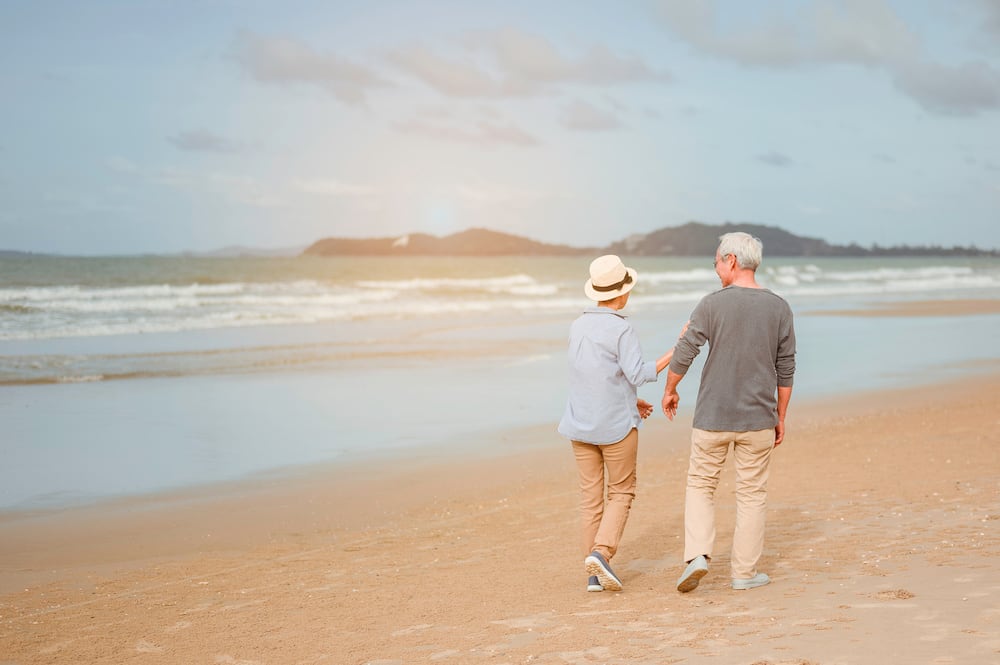 older couple holding hands on a beach