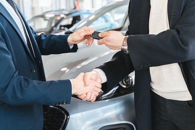 man handing car keys to another person
