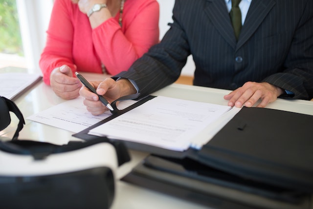 two people sitting in front of estate planning documents