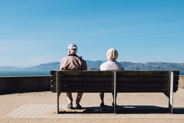 elderly adults sitting on bench