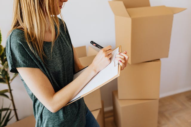 woman with checklist in front of boxes