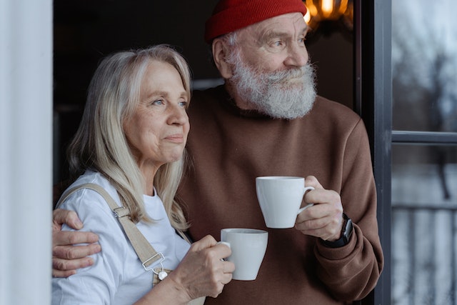 older couple smiling and holding mugs